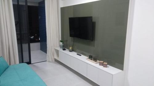 a living room with a television on a wall at Apartamento de luxo no coração da ponta verde in Maceió