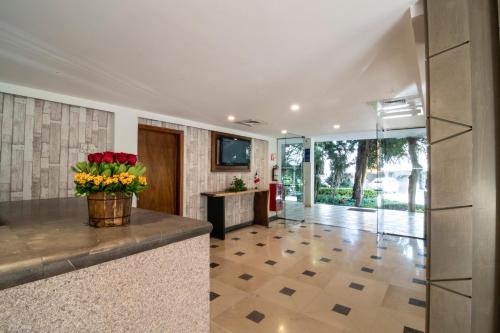 a lobby with a counter with a vase of flowers at Hotel Ronda Minerva in Guadalajara