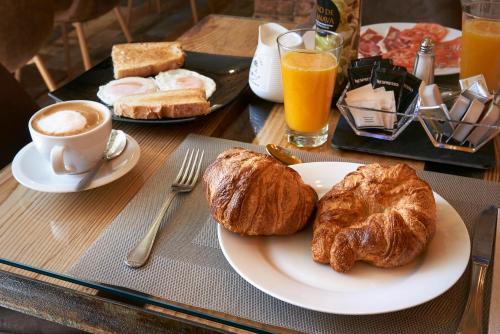 una mesa con un plato de cruasanes y una taza de café en Habitaciones Premium Finca la Casona, en San Rafael
