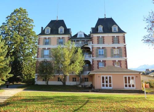 un gran edificio rosa con un gran patio en VILLA BONVOULOIR en Bagnères-de-Bigorre