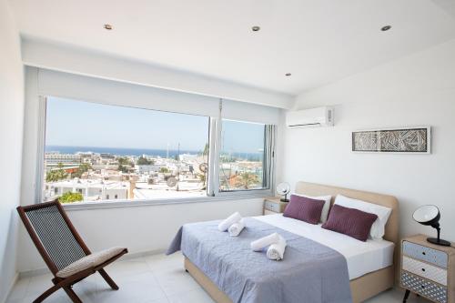 um quarto com uma cama e uma grande janela em Rio Luxury Apartment em Agia Napa