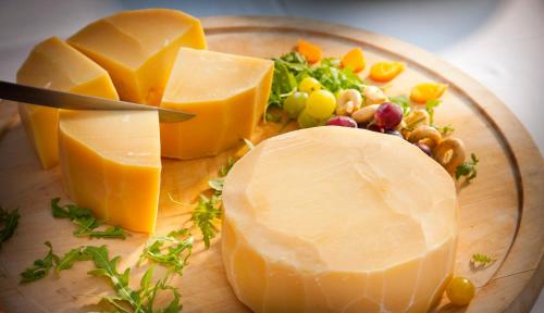 a plate of cheese and vegetables on a cutting board at Villa Amalia - by Liburnia Hotels & Villas in Opatija