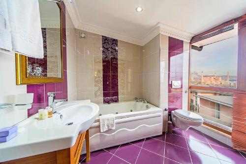 Un baño con bañera, lavabo e inodoro. en Lausos Hotel Sultanahmet, en Estambul