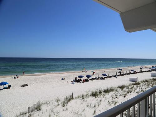 - une plage avec des parasols et des personnes sur la plage dans l'établissement Harbor House B4 Condo, à Gulf Shores
