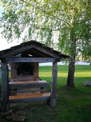 a dog house in a park with a tree at Sodyba Vieversynė in Duokiškis