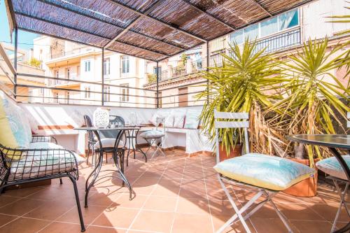 un patio extérieur avec des tables, des chaises et des plantes dans l'établissement tuGuest Gran Vía Apartments, à Grenade