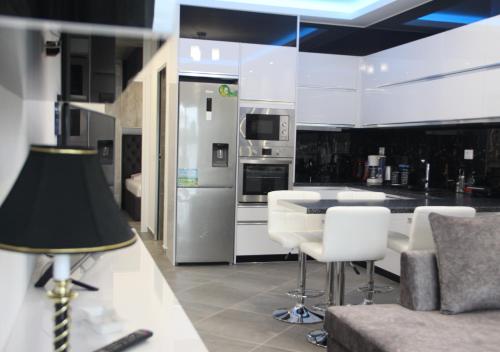 a kitchen with white appliances and a table and chairs at Le Gjero luxury villa in Ksamil