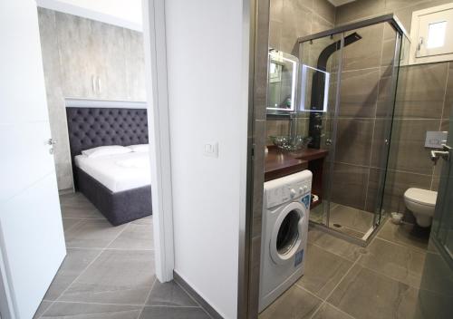 a bathroom with a washing machine in a bathroom at Le Gjero luxury villa in Ksamil