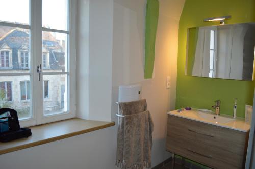 a bathroom with a sink and a window at Logement Nénuphar in Avallon