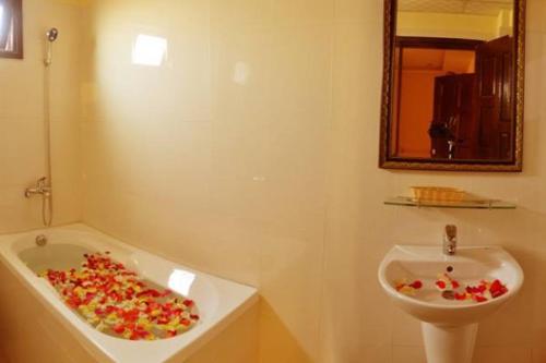 a bathroom with a sink and a bath tub at Champa Hue Hotel in Hue