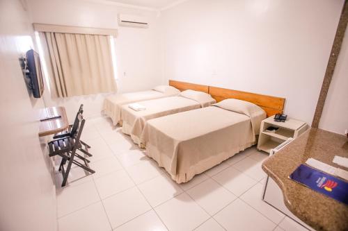 Un pat sau paturi într-o cameră la Barravento Praia Hotel