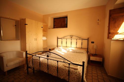 a bedroom with a bed and a chair in it at Agriturismo Nociquerceto in Tarano