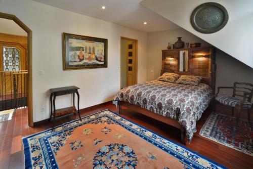a bedroom with a bed and a rug at Appartement Mogador in Honfleur