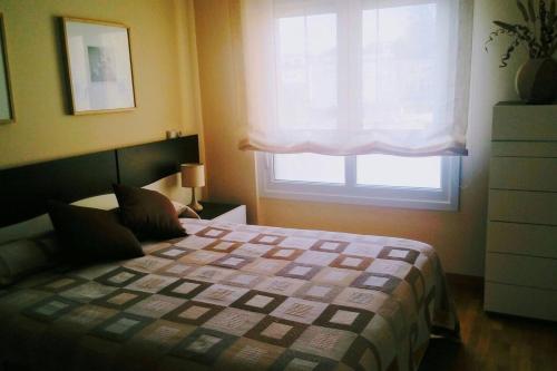 a bedroom with a bed in front of a window at Foz vacaciones a orillas del mar in Foz