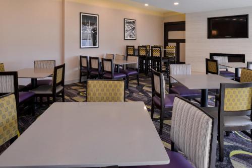a dining room with tables and chairs at La Quinta by Wyndham Indianapolis South in Indianapolis