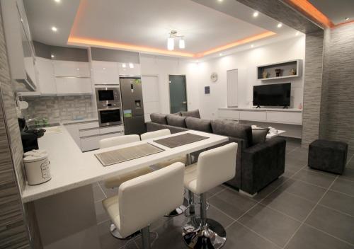 a kitchen and living room with a table and chairs at Le Gjero luxury villa in Ksamil