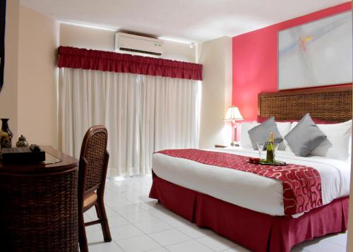 a hotel room with a large bed and a desk at Aparthotel Guijarros in Tegucigalpa