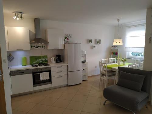 a kitchen with white appliances and a table with a chair at Apartment - Ivo in Čižići