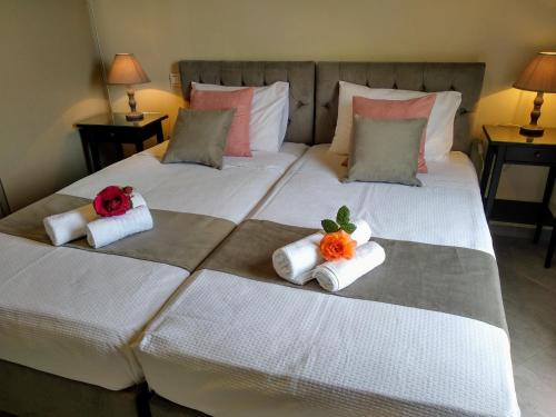 two beds with towels and flowers on them at Cephalonian Countryside Villa in Divarata