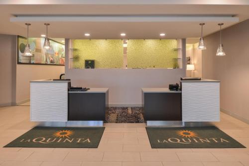 a lobby of a salon with two counters at La Quinta by Wyndham Indianapolis South in Indianapolis