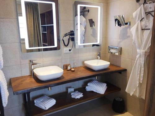 a bathroom with a sink and two mirrors at Aux Terrasses in Tournus