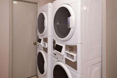two washing machines in a room next to a door at La Quinta by Wyndham Indianapolis South in Indianapolis