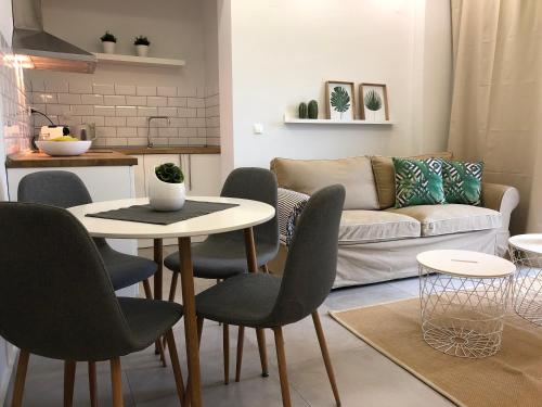 a living room with a table and chairs and a couch at Votsalo in Kavala