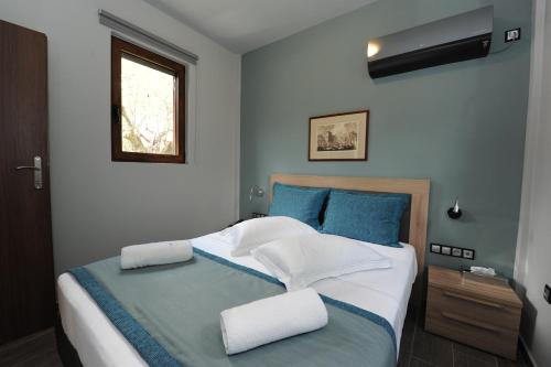 a bedroom with a large bed with blue and white pillows at Castle View Bungalows in Mystras