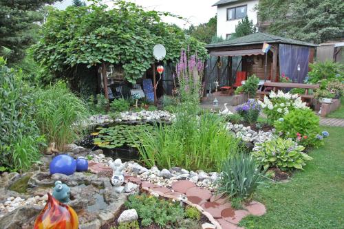 a garden with a pond and a garden with flowers at Ferienwohnung Sauer in Hillscheid