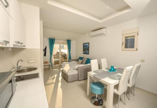 a kitchen and living room with a table and a couch at Sea Point Apart hotel Tivat in Tivat