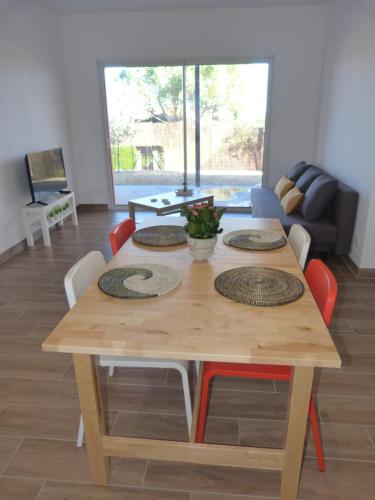 - une table à manger en bois avec des chaises et un canapé dans l'établissement Les Lodges - Villa avec spa privatif, à Valensole