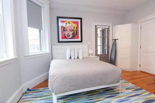 a white bedroom with a bed and a rug at A Stylish Stay w/ a Queen Bed, Heated Floors.. #23 in Brookline