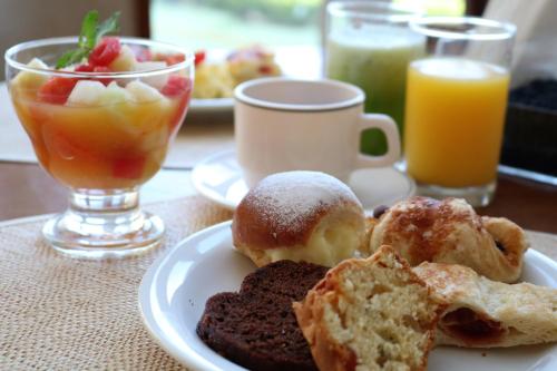 um prato de comida com bolos e bebidas numa mesa em Hotel Estoril em Campos do Jordão