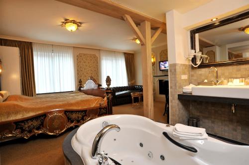 a bathroom with a bath tub and a bedroom at Villa Rubenshof in Helmond