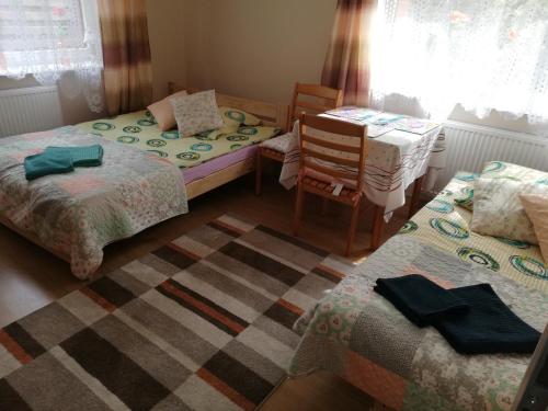 a bedroom with two beds and a table and chairs at Pokoje gościnne Zenon Nogal in Świnoujście