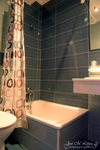 a bathroom with a tub and a toilet and a sink at Hostal Restaurante El Final in El Cabaco