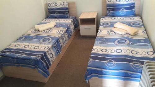 two beds in a room with blue and white sheets at Sevan EM & YU in Sevan