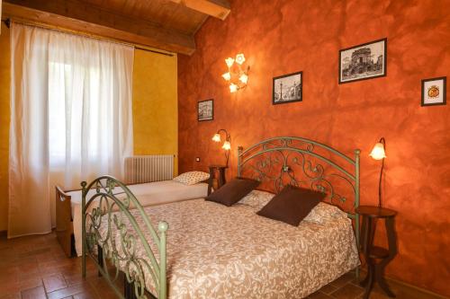 1 dormitorio con 1 cama en una habitación con paredes de color naranja en La Vecchia Stazione Ravenna, en Rávena