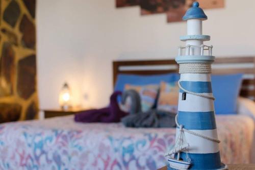 a figurine of a lighthouse in front of a bed at Buda in Tinajo
