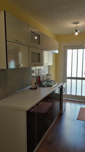 a kitchen with brown cabinets and a counter top at Rooms & Apartment Jozić in Prozor