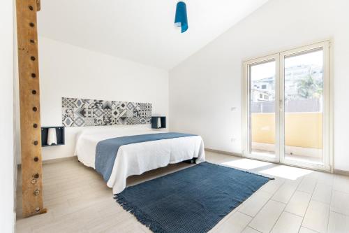 Dormitorio blanco con cama y alfombra azul en Villa Uluvud by Xenia Sicily Villas en Alcamo