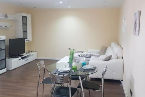 ein Wohnzimmer mit einem Tisch und einem weißen Sofa in der Unterkunft Centro Castillo 9 in Cáceres