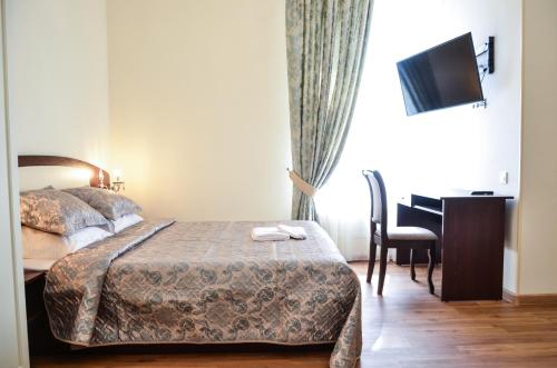 a hotel room with a bed and a desk with a computer at Apartment nr. 8 in Odesa