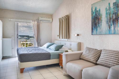 a bedroom with a bed and a couch at Panorama Fanari studios and apartments in Argostoli