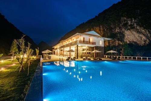 a resort with a swimming pool at night at Mai Chau Mountain View Resort in Mai Chau