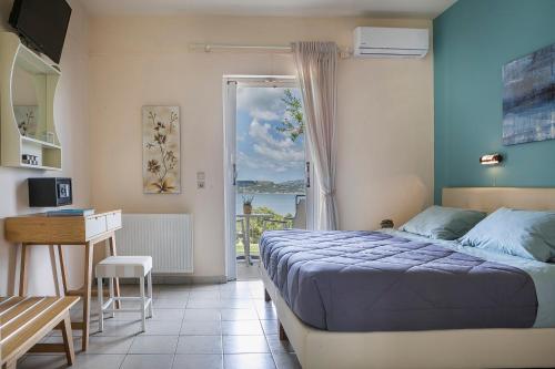 a bedroom with a bed and a desk and a window at Panorama Fanari studios and apartments in Argostoli