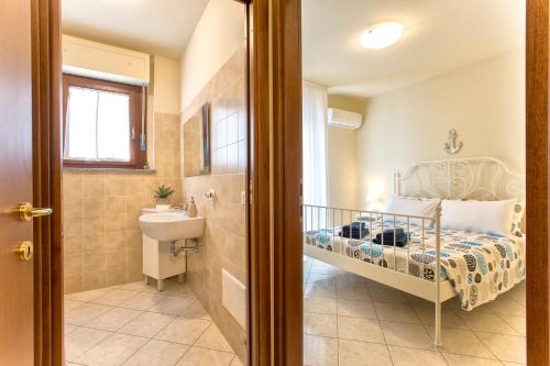 mała łazienka z łóżkiem i umywalką w obiekcie white coral bedrooms self check-in w mieście Alghero