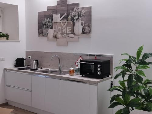 una cocina con fregadero y microondas en Judaica d'Ortigia, en Siracusa