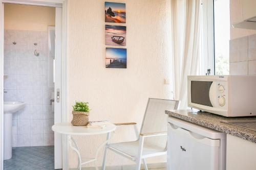 a kitchen with a table and a tv on a counter at Panorama Fanari studios and apartments in Argostoli