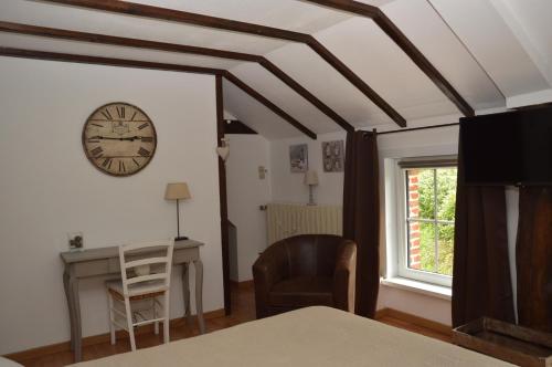 Cette chambre dispose d'un réveil, d'un bureau et d'une chaise. dans l'établissement Le Relais du Biau Ri, à Clairfayts